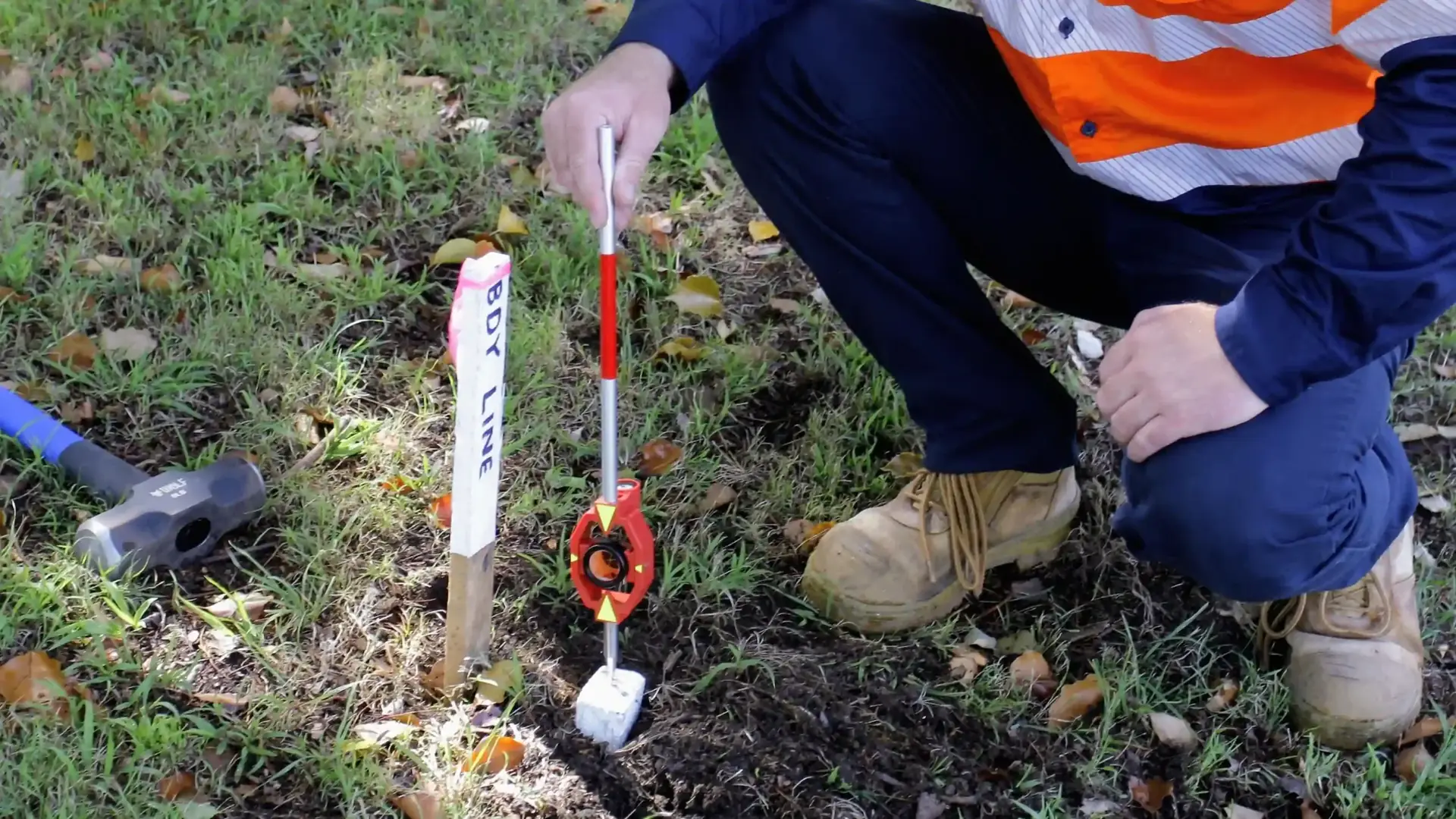 Surveyor placing cadastral boundary peg in Five Dock Sydney residential property
