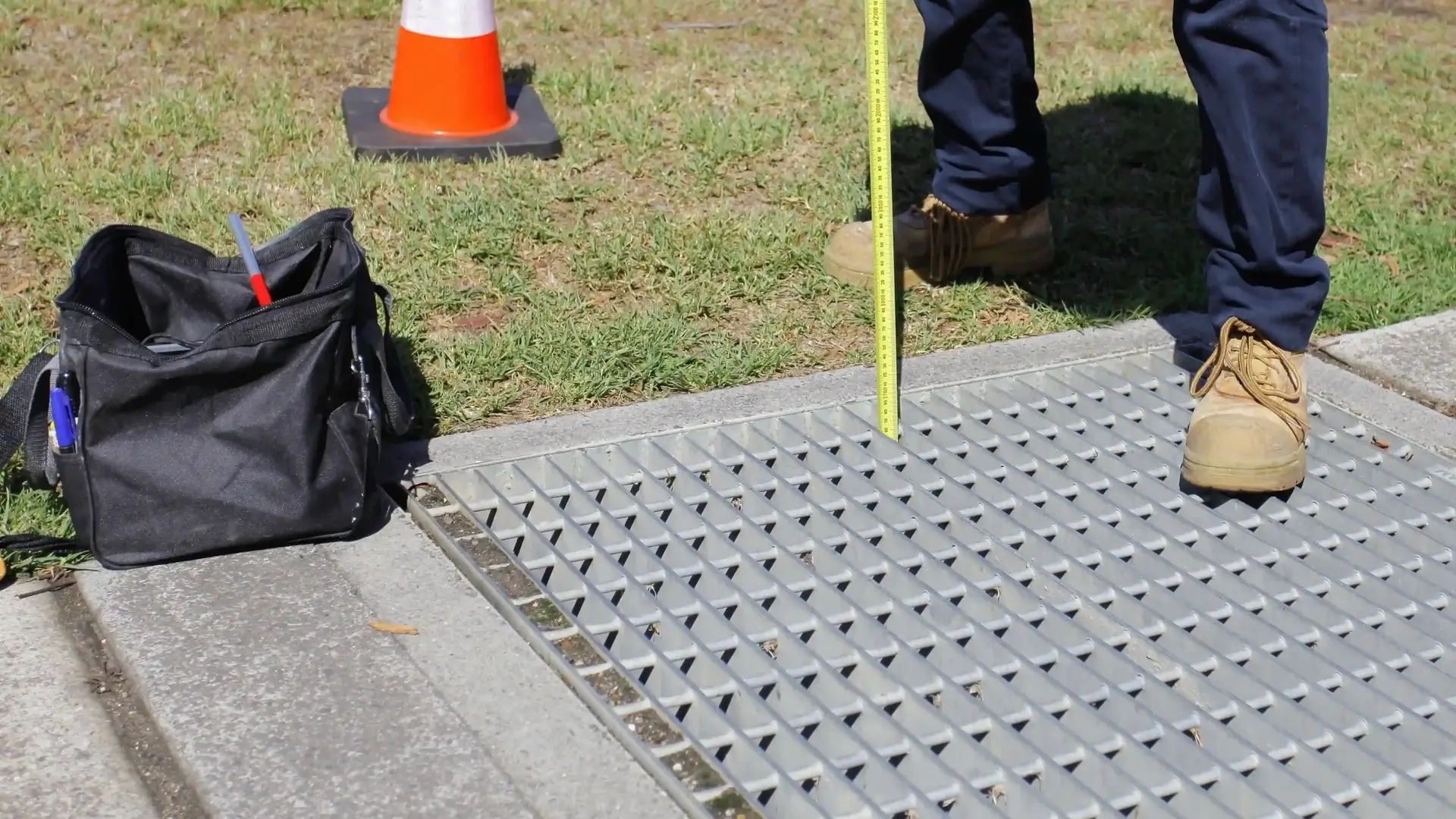Surveyor measuring stormwater pit for work as executed survey in Sydney Inner West